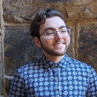 Alex Gallegos smiling and wearing a patterned blue shirt