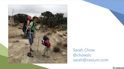 照片中，一名妇女穿着登山装备，背着一个婴儿，旁边站着一个小孩, 在多岩石的沙漠中
