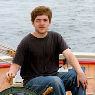Sean Lilley squinting as he steers a boat. 