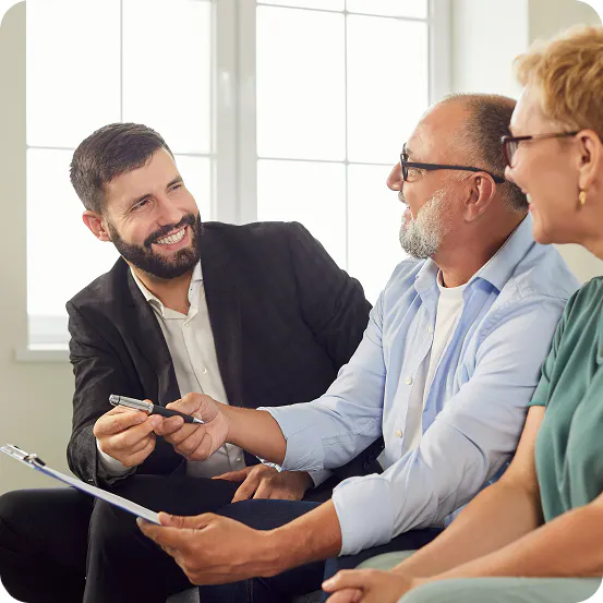 Healthcare broker pointing to plan details while explaining coverage options to two Medicare beneficiaries.