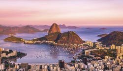 Imagem panorâmica da cidade do Rio de Janeiro, com vista do Pão de Açúcar, ao entardecer.