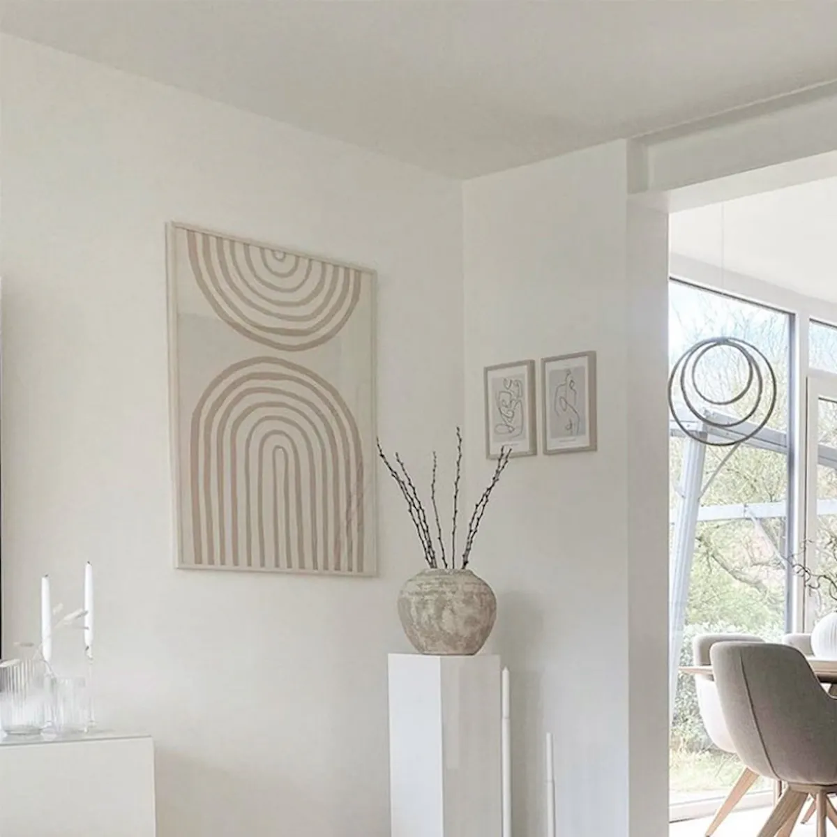 Open living room combined with dining room, light beige furnishings, Nordic style, modern graphic on wall