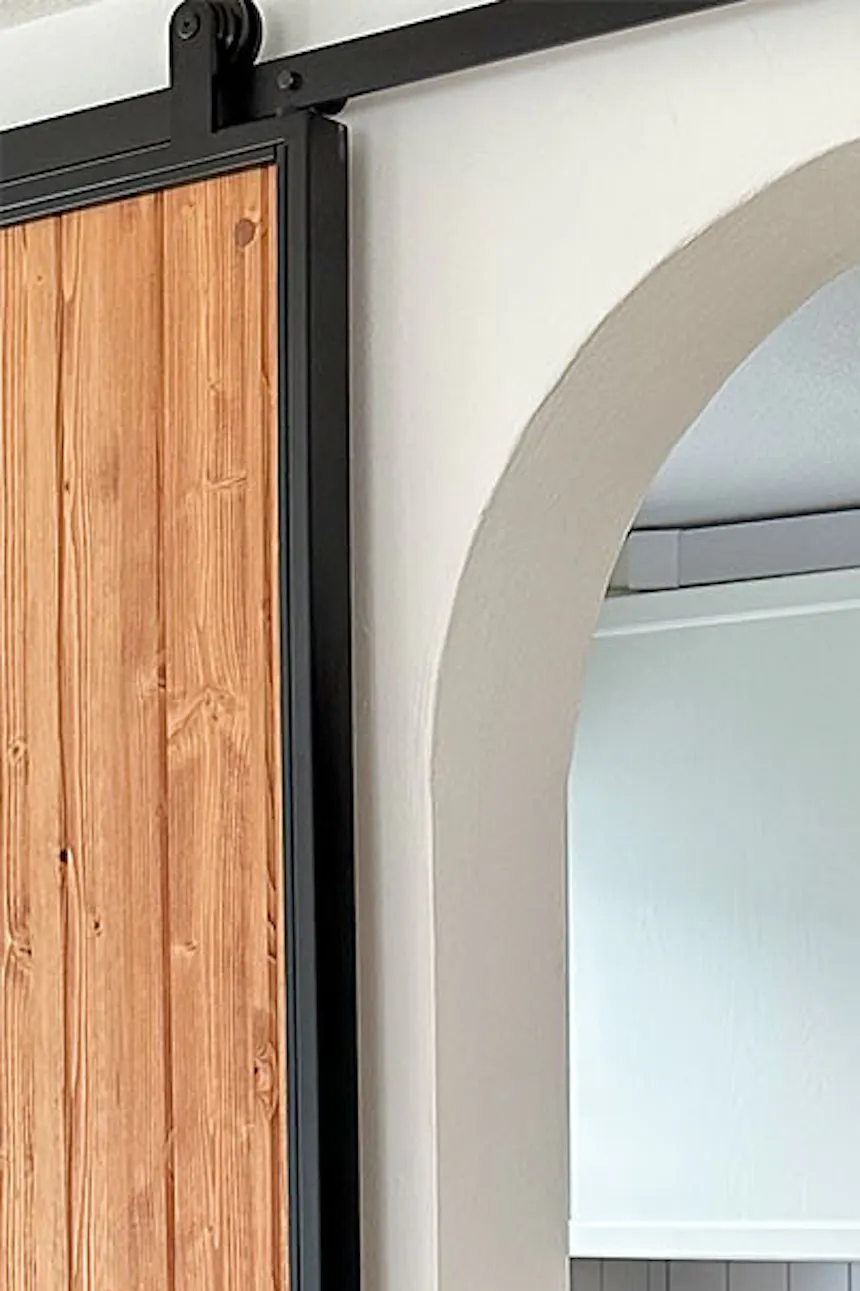 entrée de la cuisine décorée dans des tons blancs et gris avec un sol à motifs
