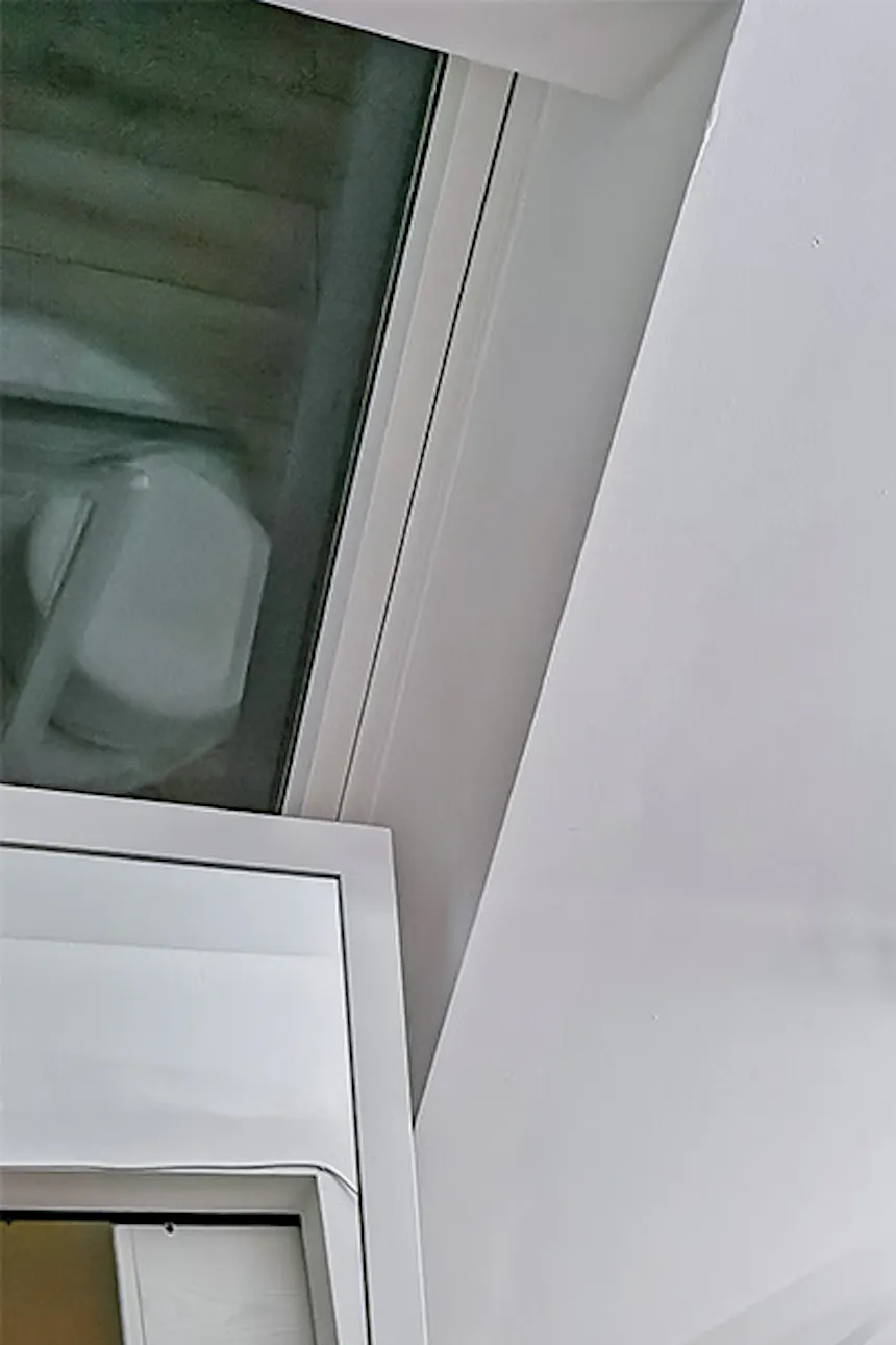un grand miroir dans un cadre blanc et des armoires et étagères blanches dans le dressing