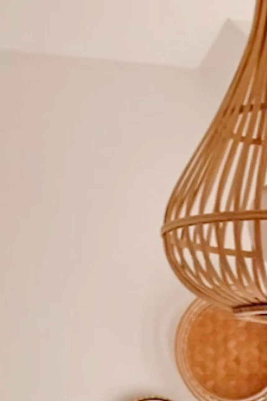 bamboo lampshade, black frame bed, white walls in the bedroom, boho style decorations above the bed in the bedroom, wooden beam on the ceiling in the bedroom, black bedside table, boho decorations in the bedroom in a natural style