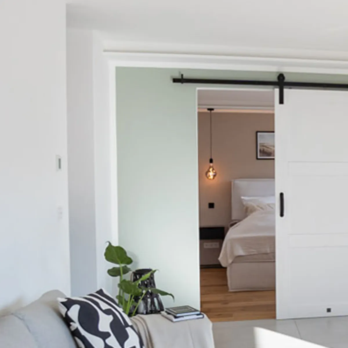Modern white sliding doors, gray sofa, pouf with geometric patterns, minimalist decorations, modern living room