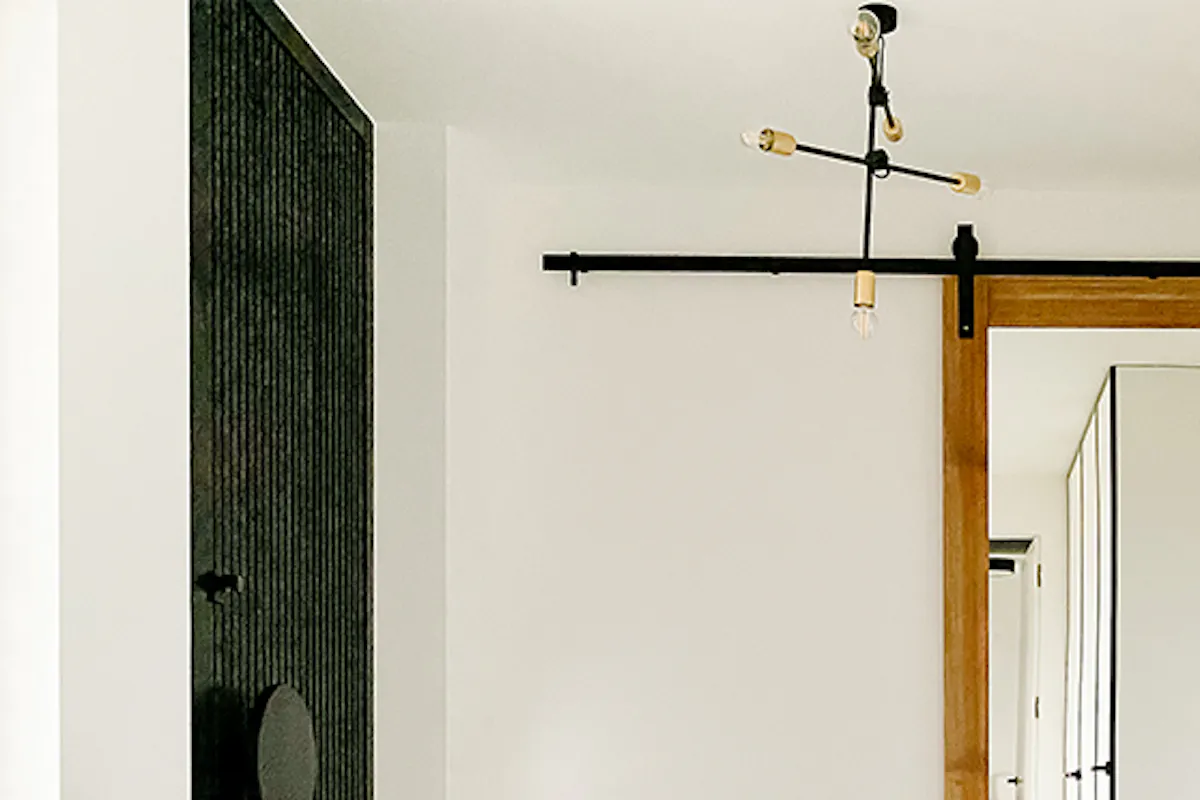 Mirror door in entryway, large mirror in wooden frame, industrial lamp, microcement floor, entryway bench