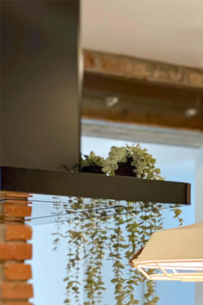 White industrial lamp above kitchen island, black pantry door, kitchen with pantry