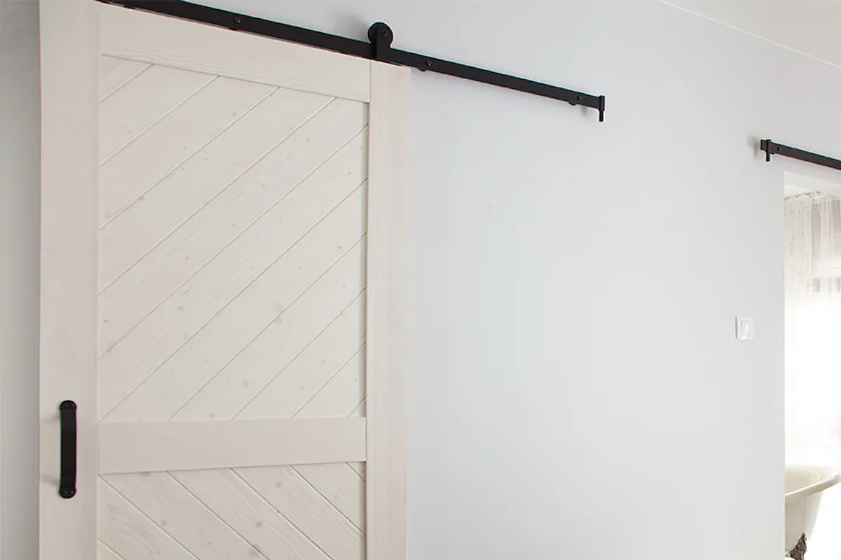 white sliding door to the bathroom in a bedroom decorated in Provencal style