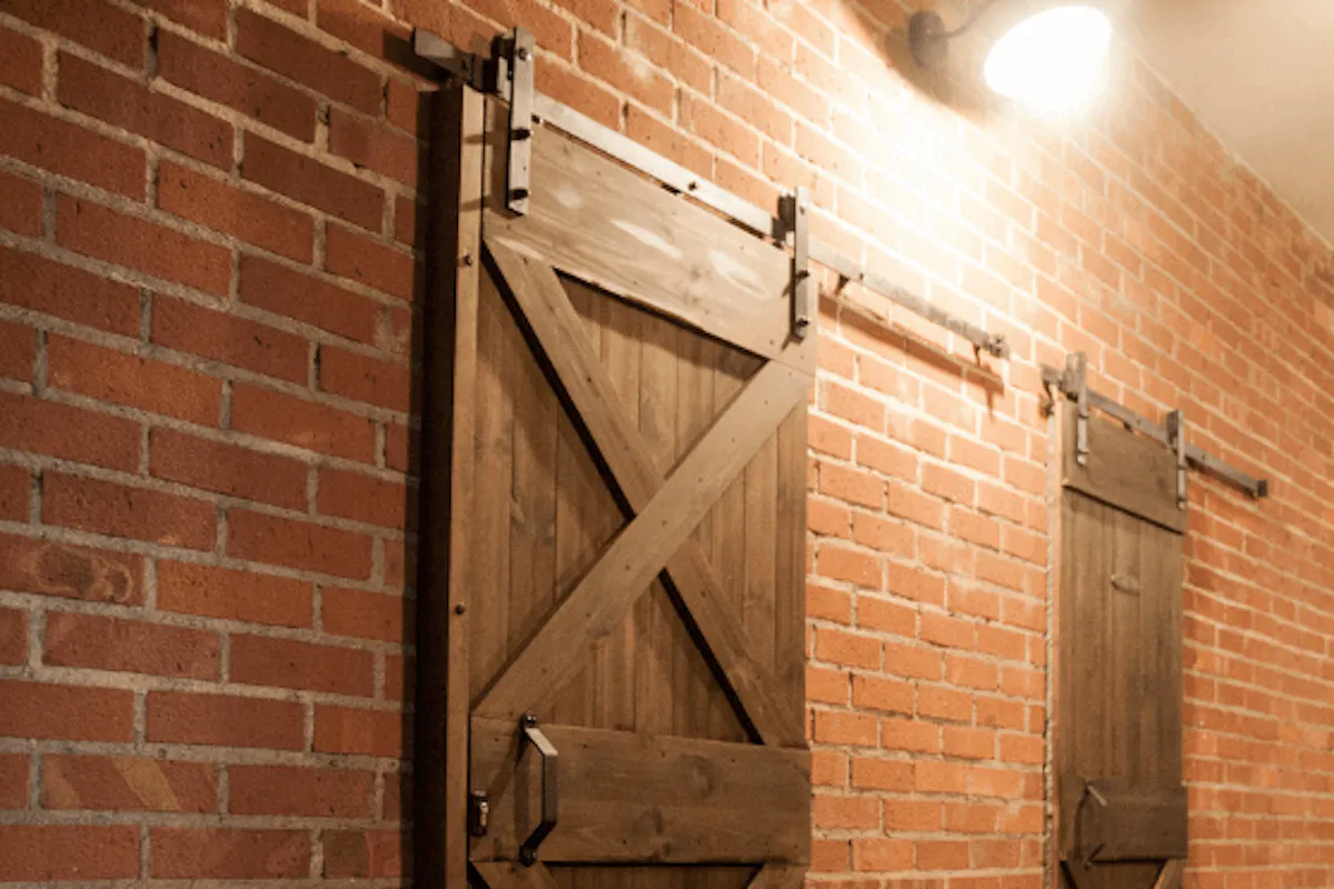 porte coulissante en bois massif sur mur de briques