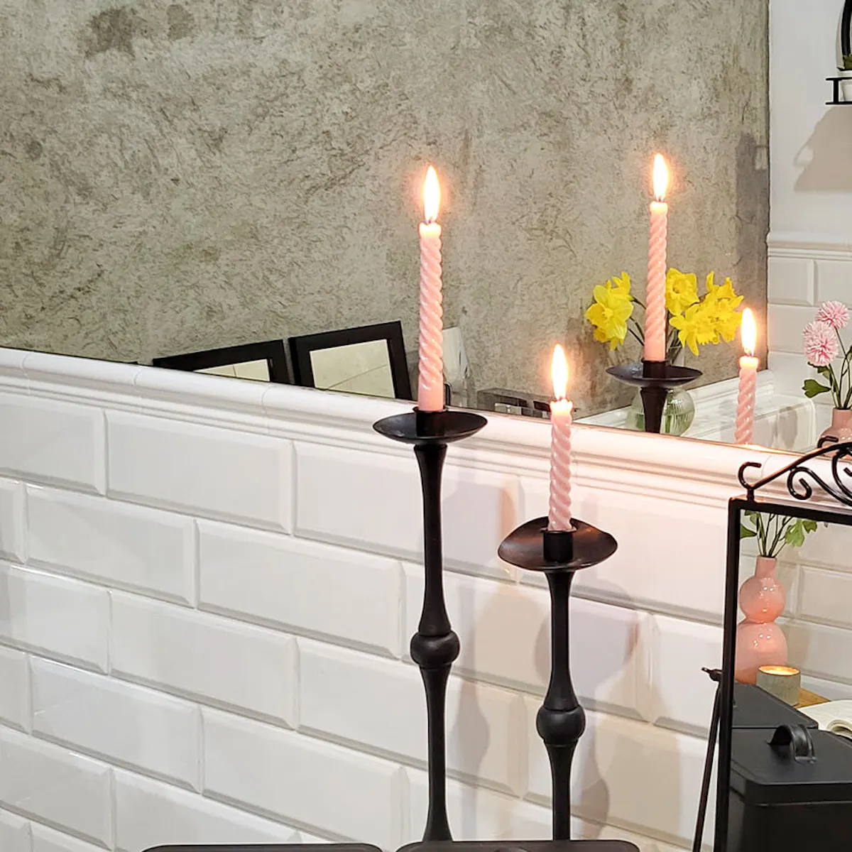 black containers, mirror and decorative candlesticks on the bathroom counter
