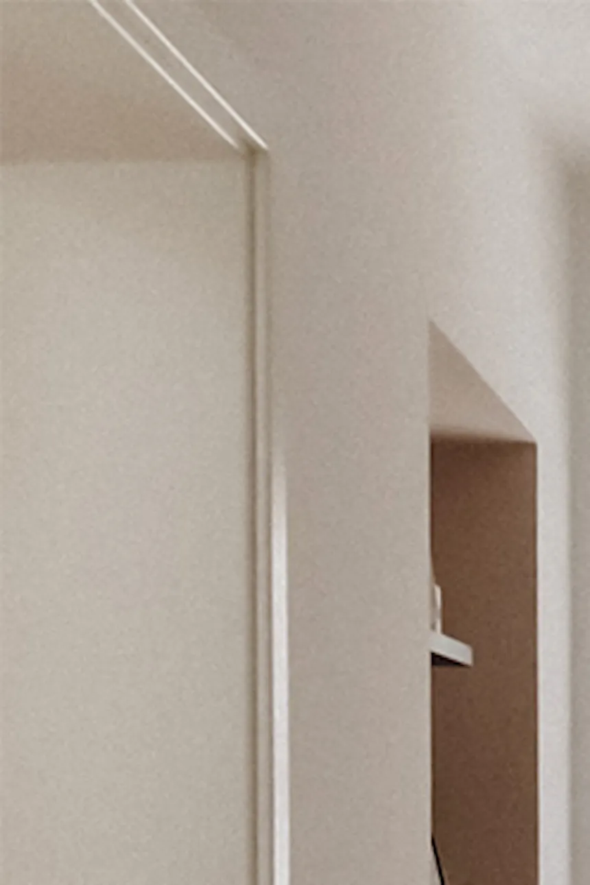 Glass door at end of hallway leading to living area, light walls, minimalist hallway décor.