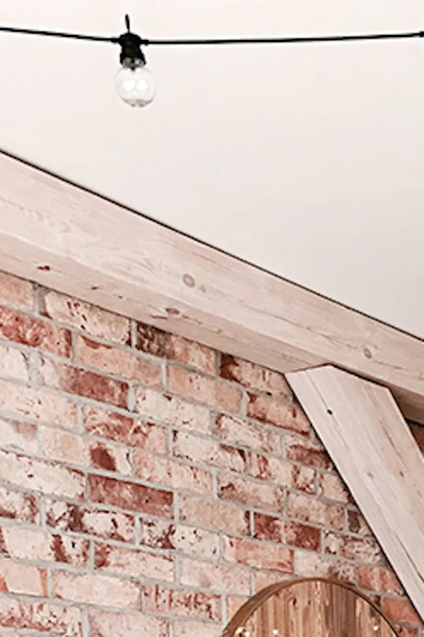 rustic bedroom, wooden sliding doors, bypass sliding doors, bypass wall mount for sliding doors, rustic style interior, modern rustic style, barn sliding doors, white sliding system, brick wall in bedroom, ceiling beams in bedroom, white rustic chandelier
