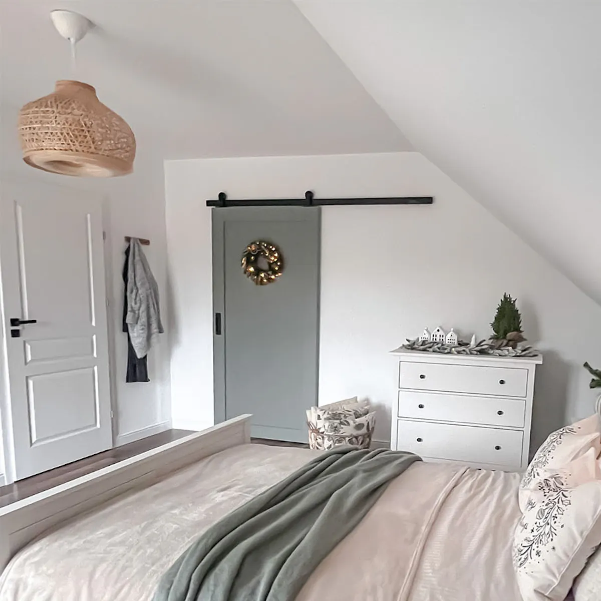 un lit placé sous plafond mansardé dans la chambre avec une armoire