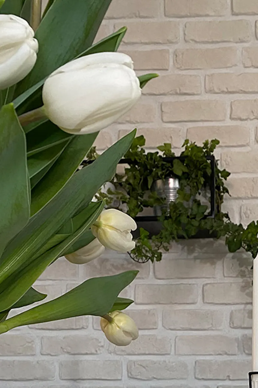 Island in kitchen, white brick on kitchen wall, flowers and décor on kitchen counter