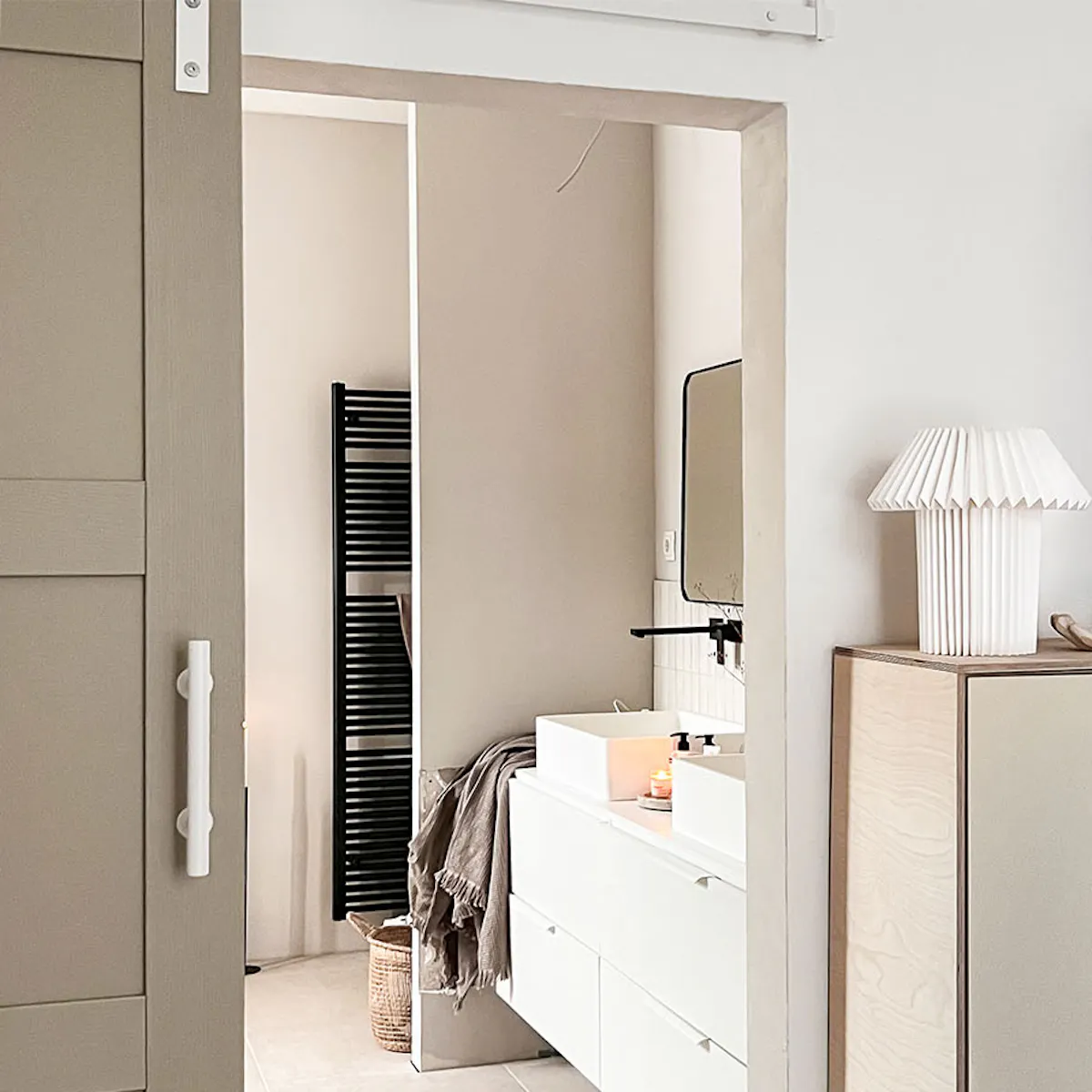 Beige minimalist dresser at entrance to modern bathroom