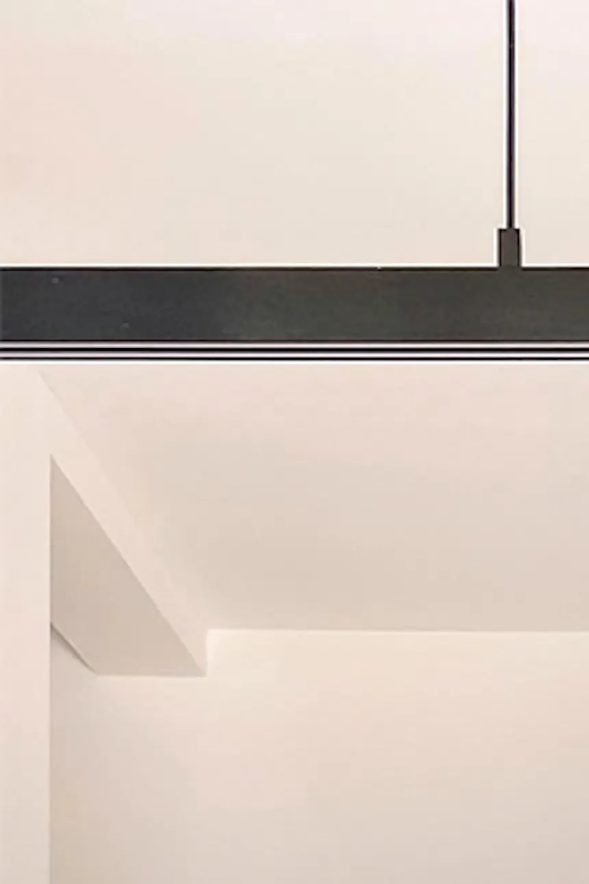Decorative vases, herringbone dining table with long minimalist pendant lamp, black accessories in minimalist interior.