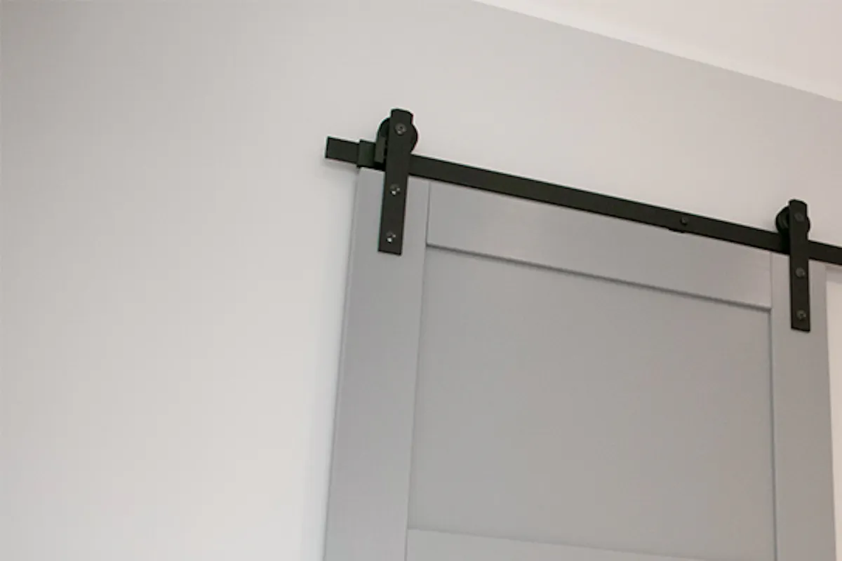 Grey sliding doors on white hallway wall.
