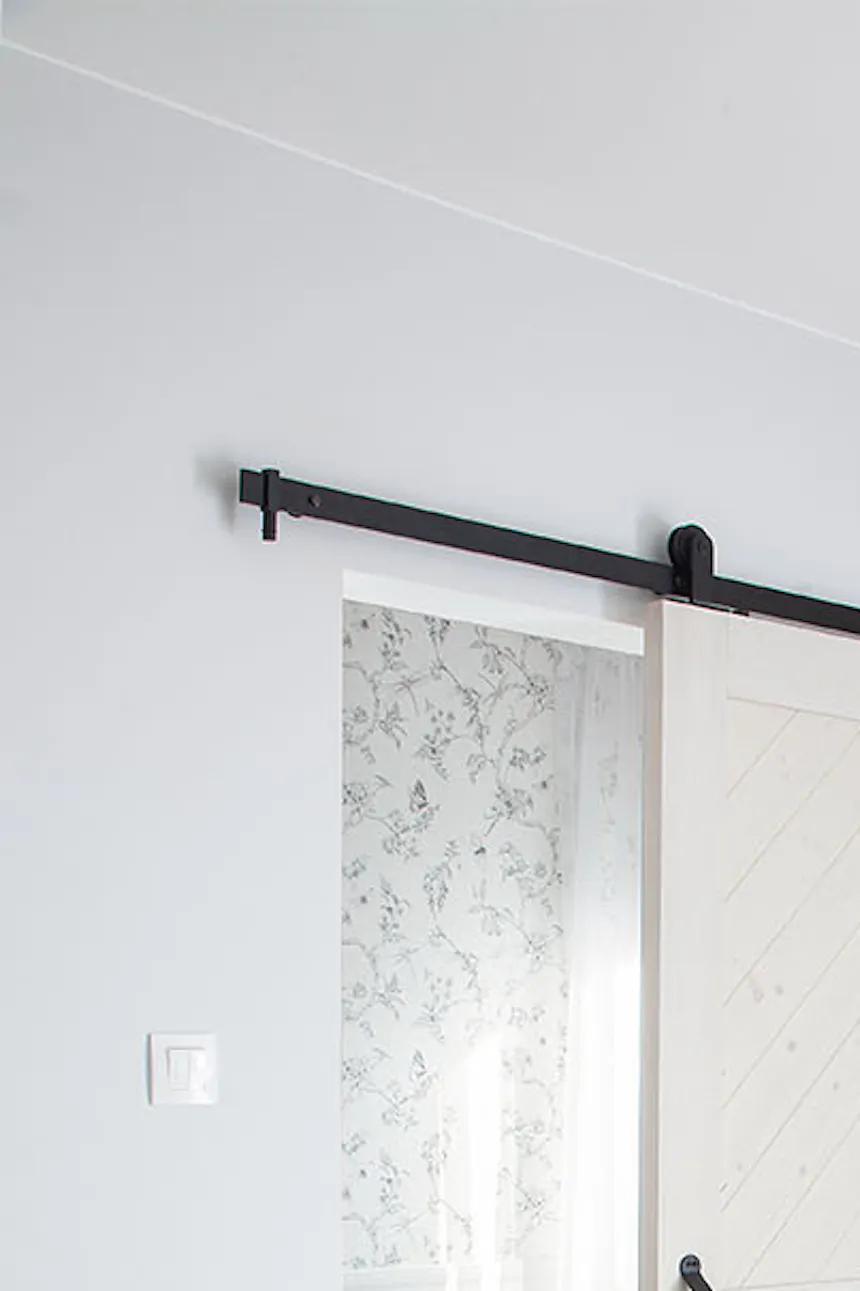 bathroom next to the bedroom separated by a white sliding door