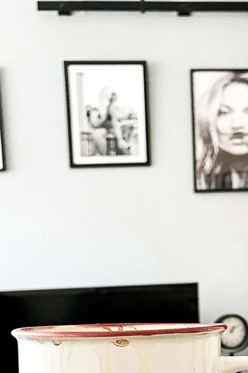 sliding doors in a small apartment, set of two black coffee tables, wooden sliding door in the living room, black and white posters on the wall, coffee cup