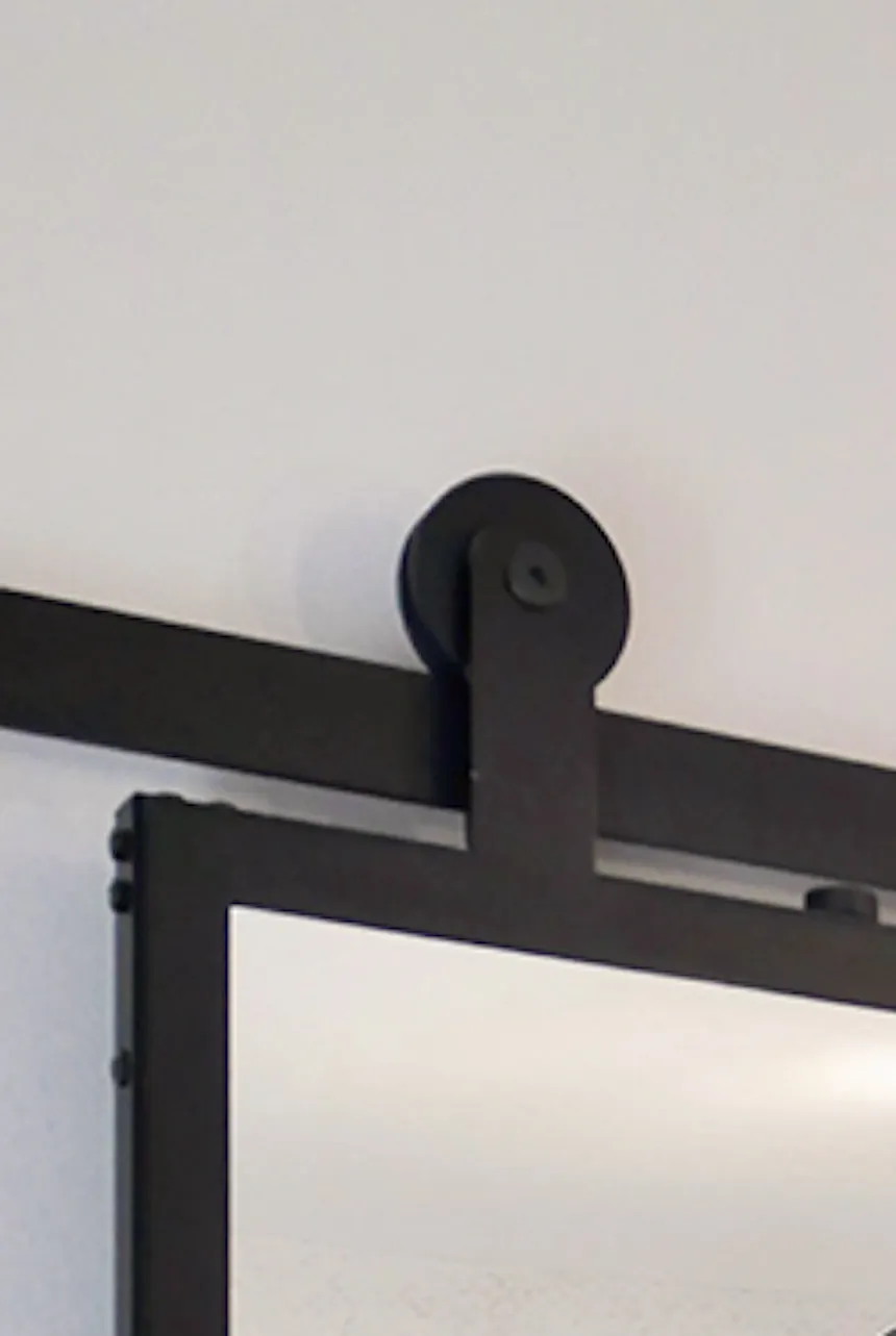 Porte coulissante avec un miroir dans un cadre en métal montrant un fragment de chambre dans un style moderne