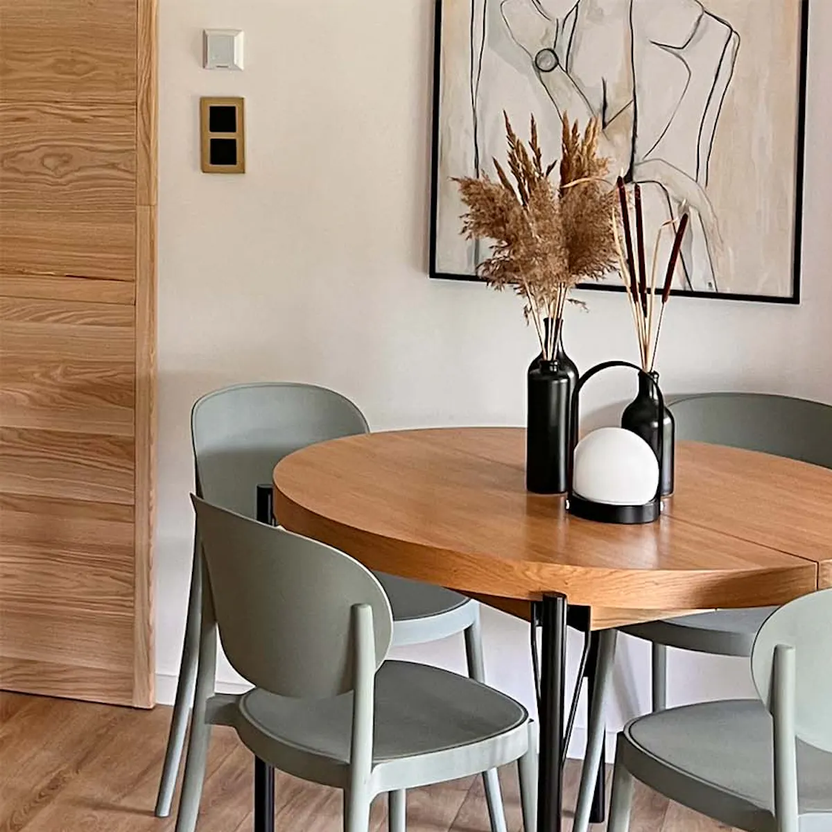 sage coloured chairs standing around a round table with a wooden top and metal legs