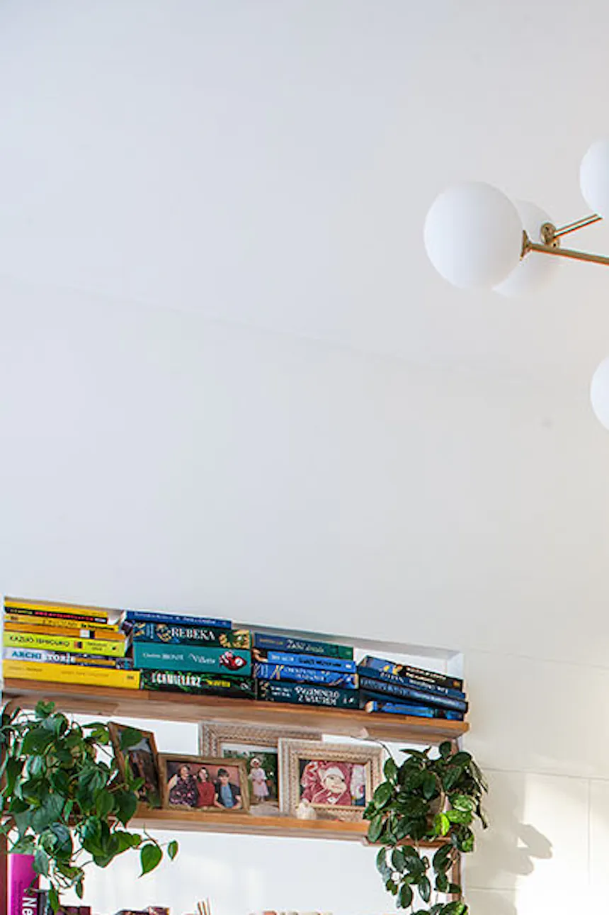 une table ronde en bois et une étagère avec des livres à l'intérieur d'un petit appartement