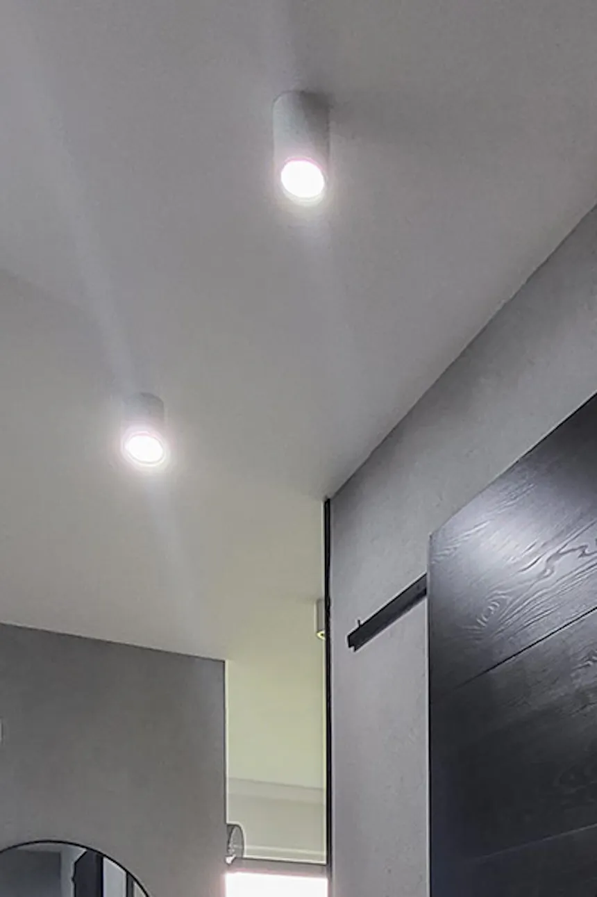 black sliding door in the entrance to the bathroom in the hallway with gray walls