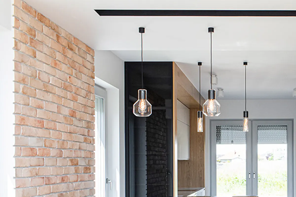 Modern kitchen, open kitchen, brick wall in kitchen, dining nook, large open kitchen, neon decoration on wall, yellow pantry door, pantry sliding door