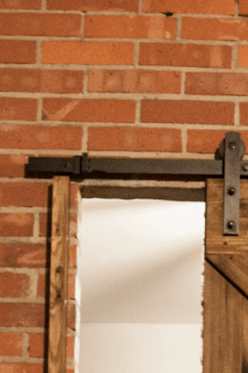 porte coulissante en bois massif sur mur de briques