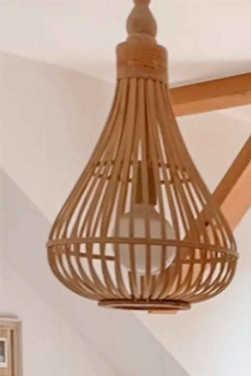 white walls in the bedroom, beige curtains, bamboo pendant lamp, black bedside table, wooden beam in the ceiling, boho style decorations in a natural bedroom