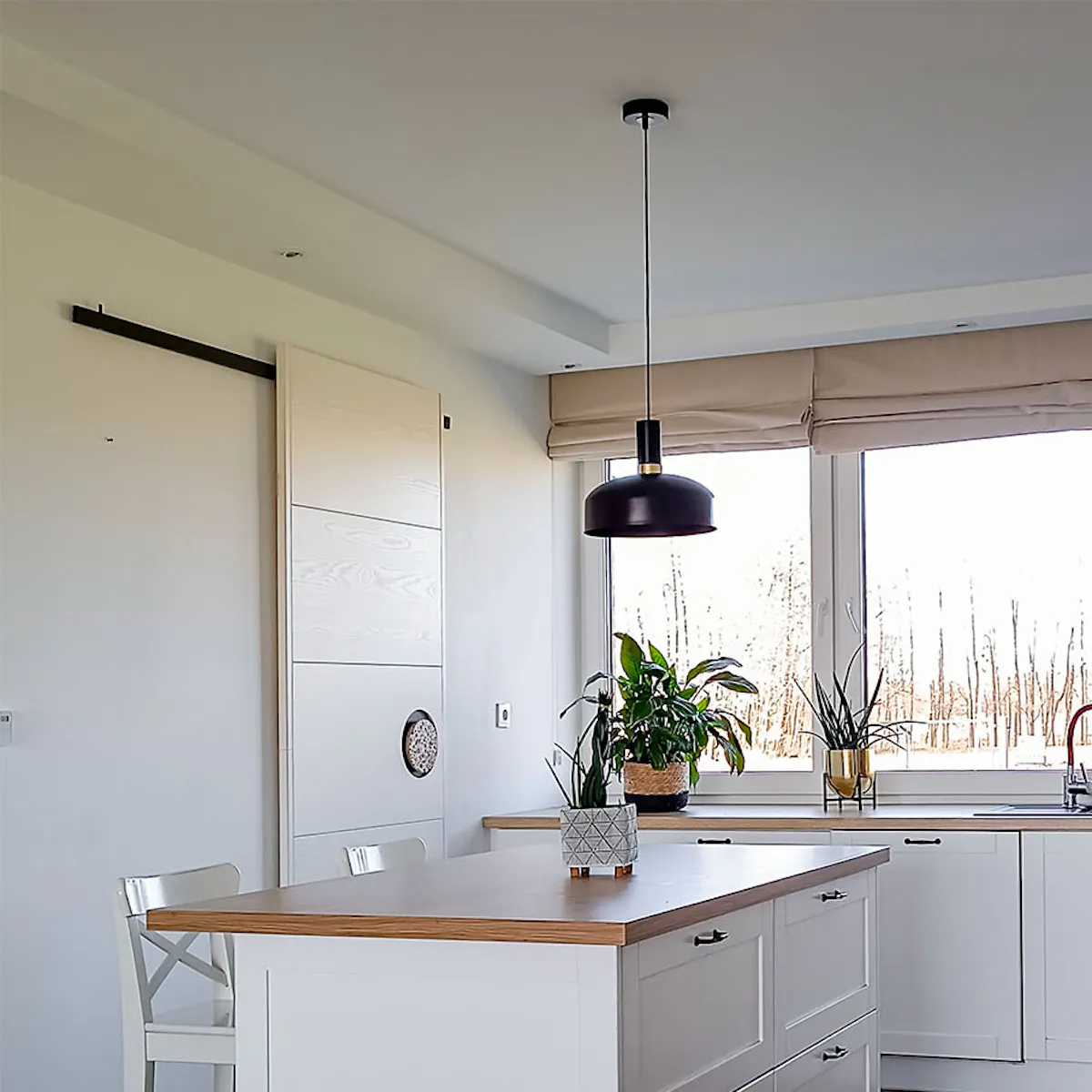 a large island in a white kitchen with a pantry