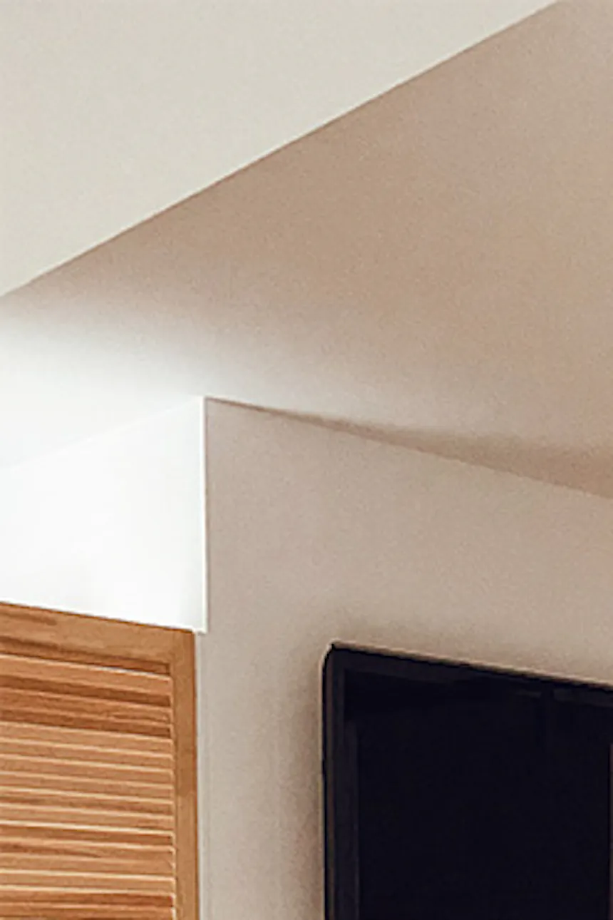 white solid wood sliding door in bedroom entrance, white walls and wooden floor in natural bedroom, bamboo pendant lamp, decorative rug in front of bed