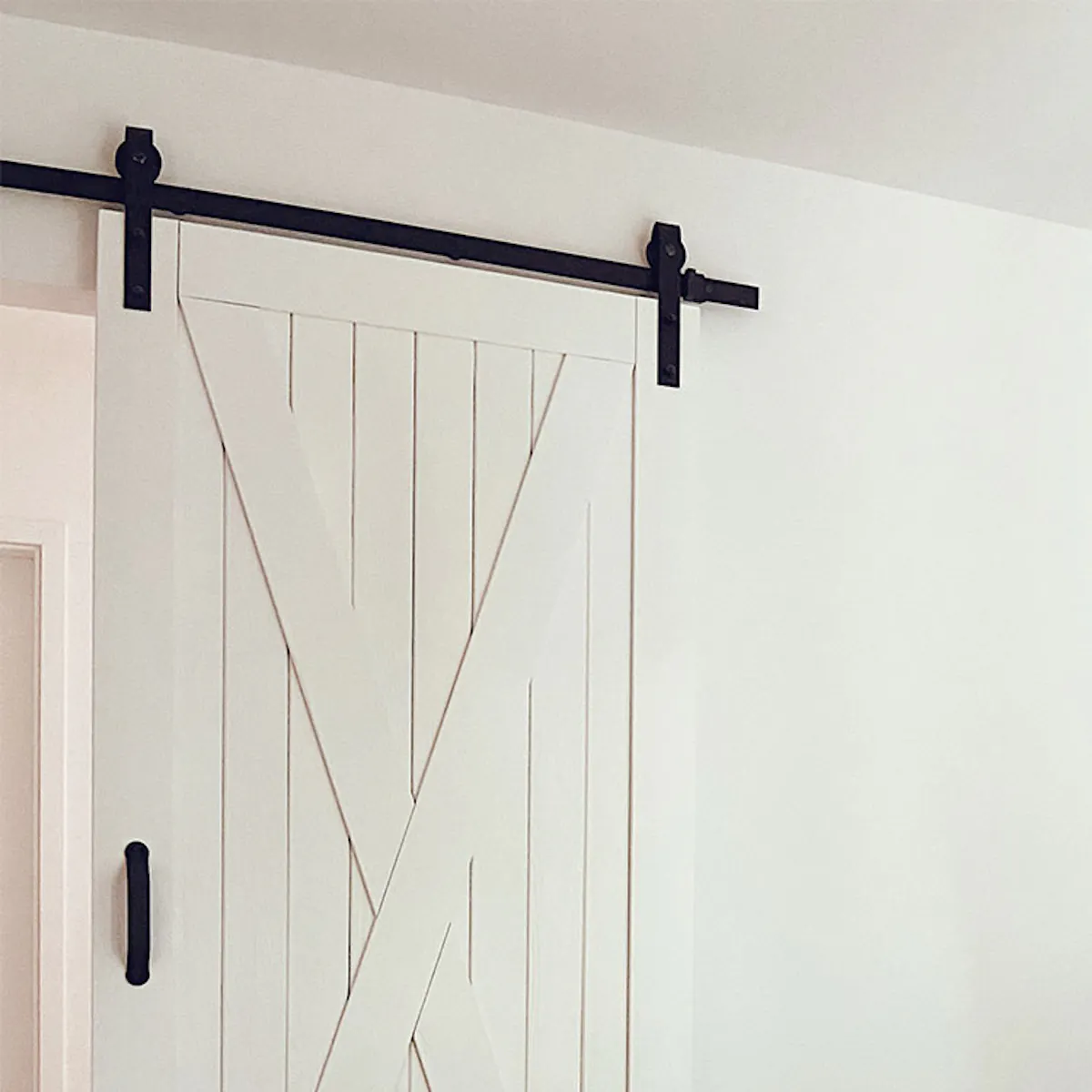 white solid wood sliding door in the entrance to the natural bedroom, white walls in the bedroom, bamboo pendant lamp, natural boho decorations on the white wall