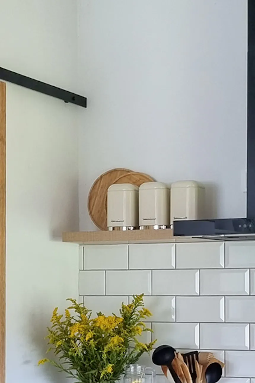 white kitchen cabinets with wooden tops and white tiles in a Scandinavian kitchen