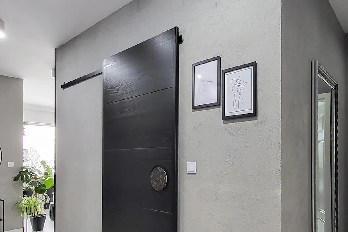 hall with gray concrete walls and black sliding doors