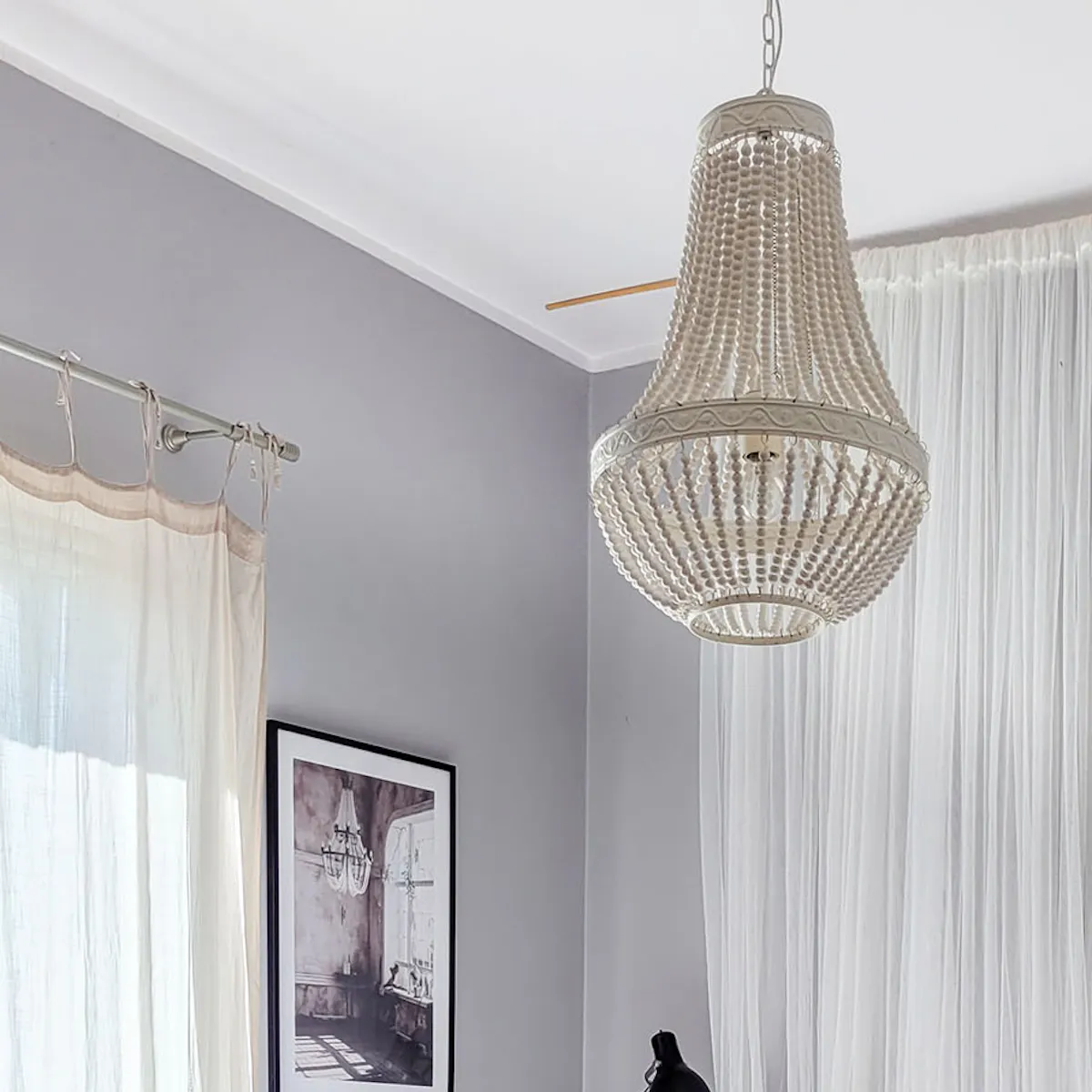 lustre en perles au-dessus du lit dans une chambre rustique moderne