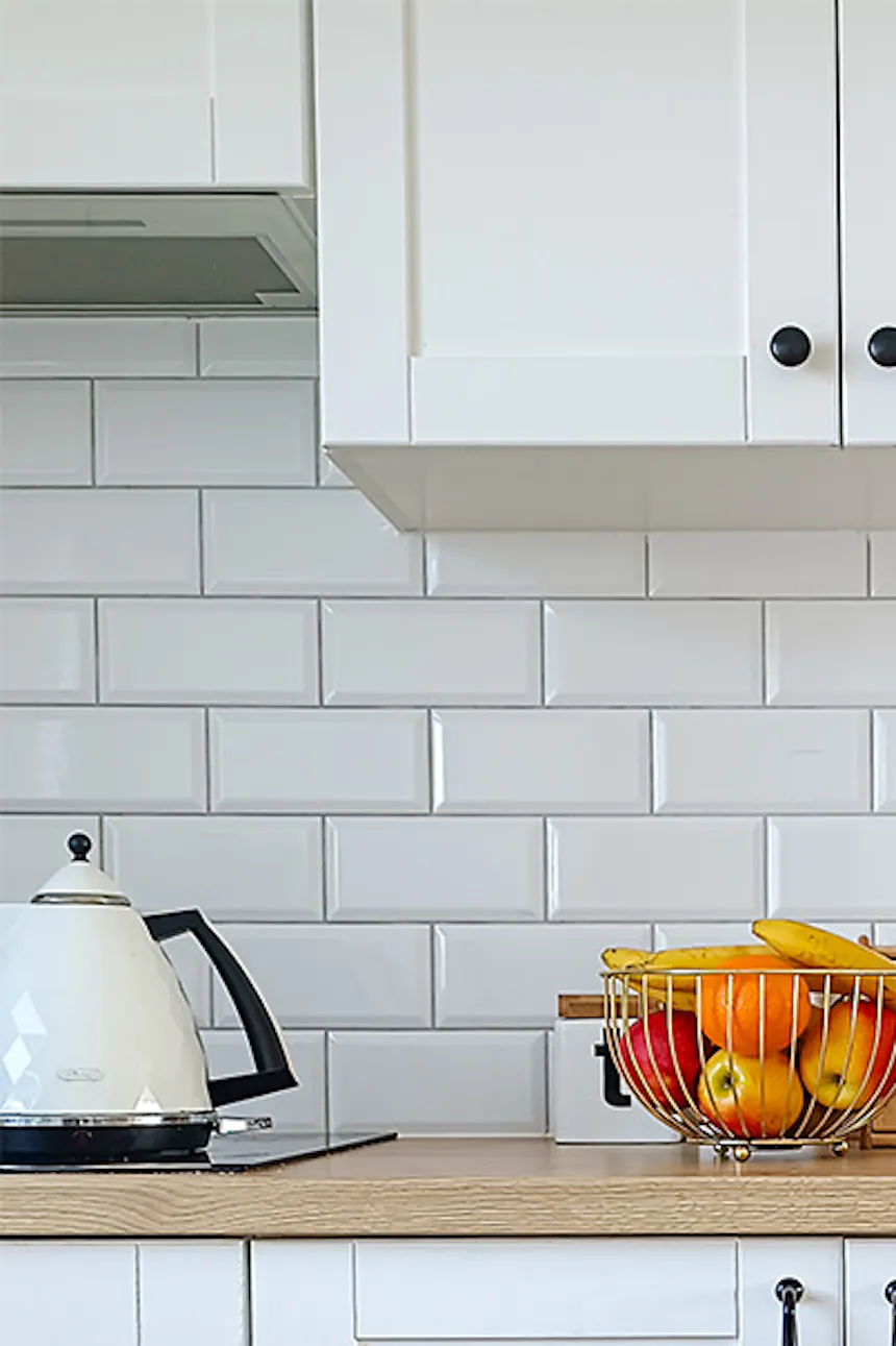 parquet, meubles blancs et carrelage blanc dans la cuisine