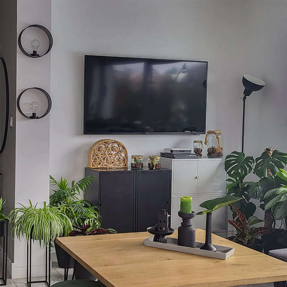 grey sofa, a loft coffee table with a wooden top, large potted plants in the living room
