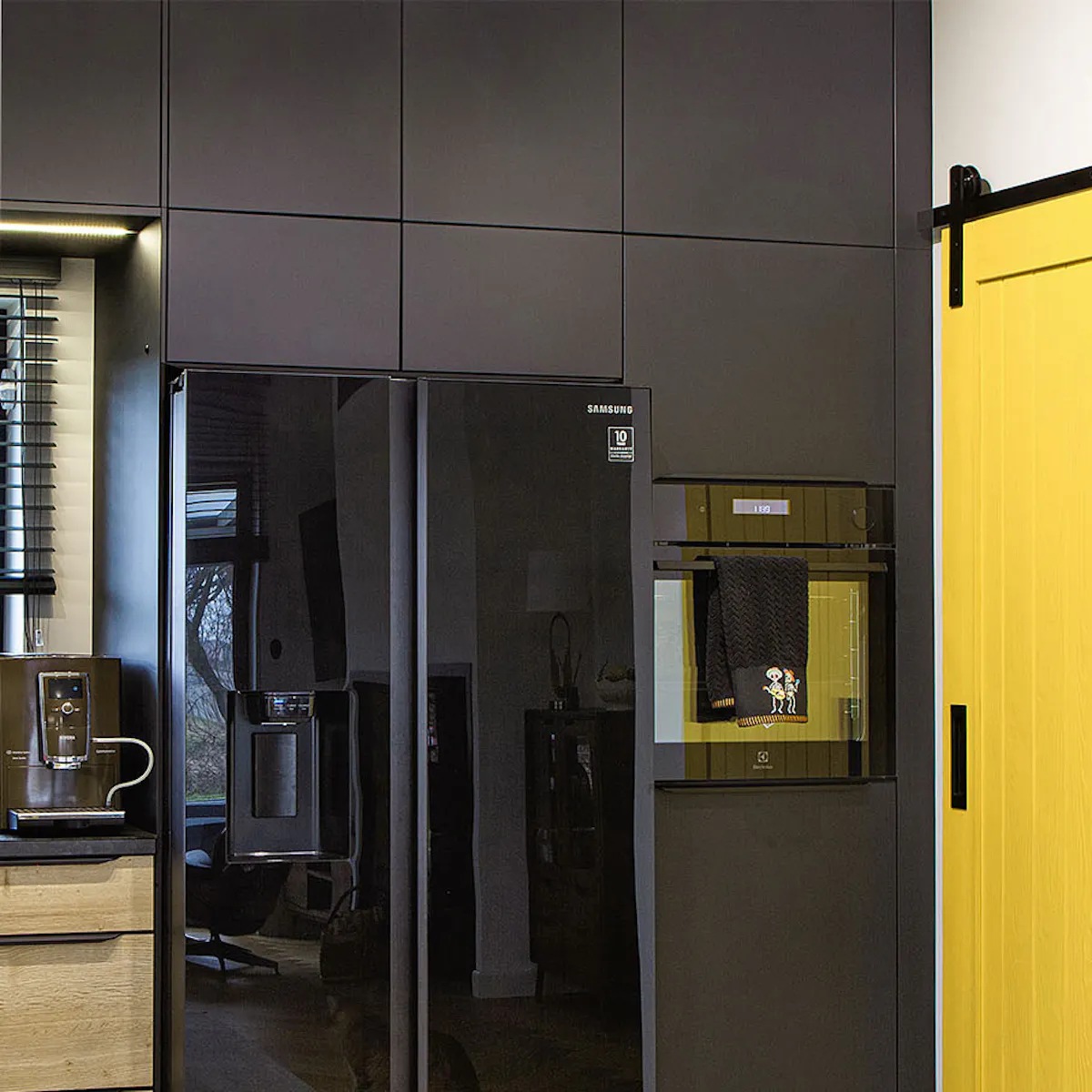 porte coulissante jaune au garde-manger de cuisine avec placards noirs