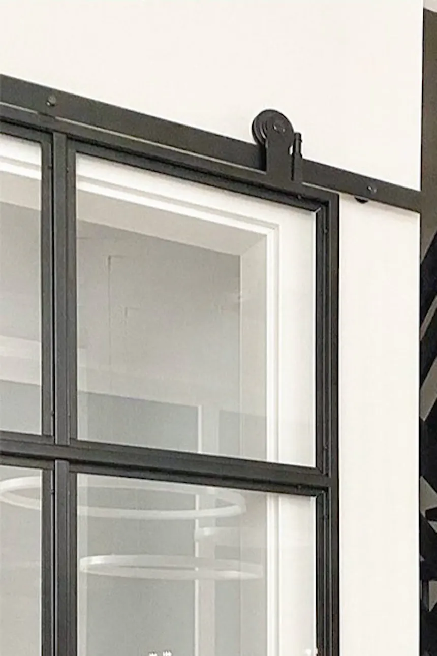 Black perforated staircase, glass doors in black metal frame