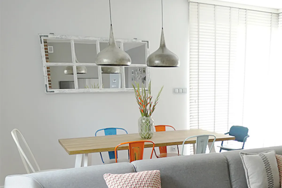 Living room arrangement with gray sofa, colorful accessories, and wall decorations