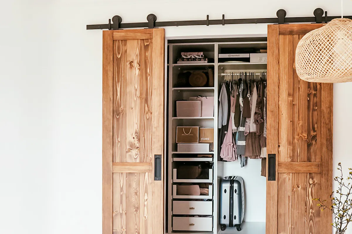 portes coulissantes étroites en bois à double battant fermant l'armoire dans une chambre naturelle