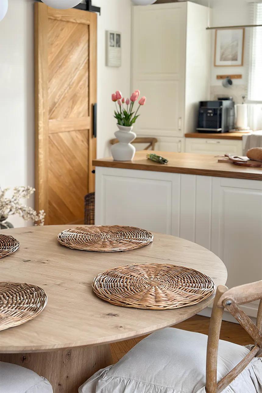 A view of a round wooden table and a closed oak sliding door.