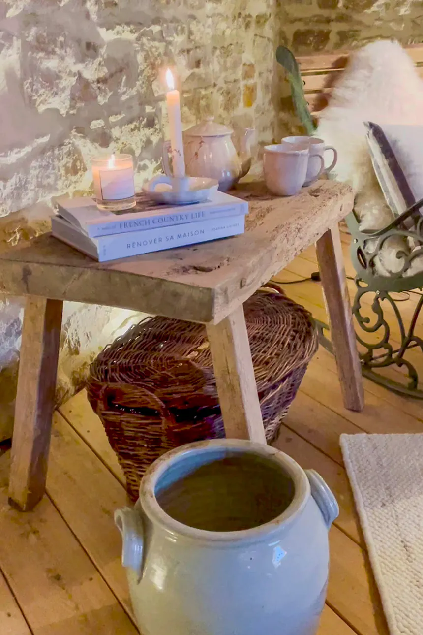 livres, bougies et plats en céramique sur un tabouret en bois