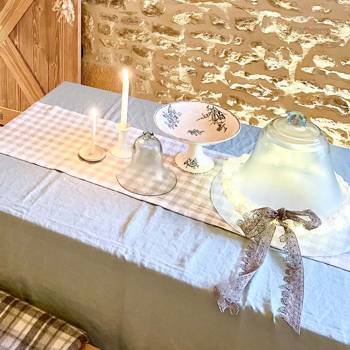 plats en verre et en porcelaine sur une table recouverte d'une nappe en lin bleu