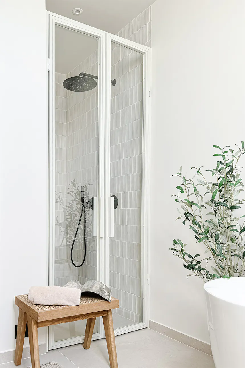 White glass door to shower enclosure in alcove