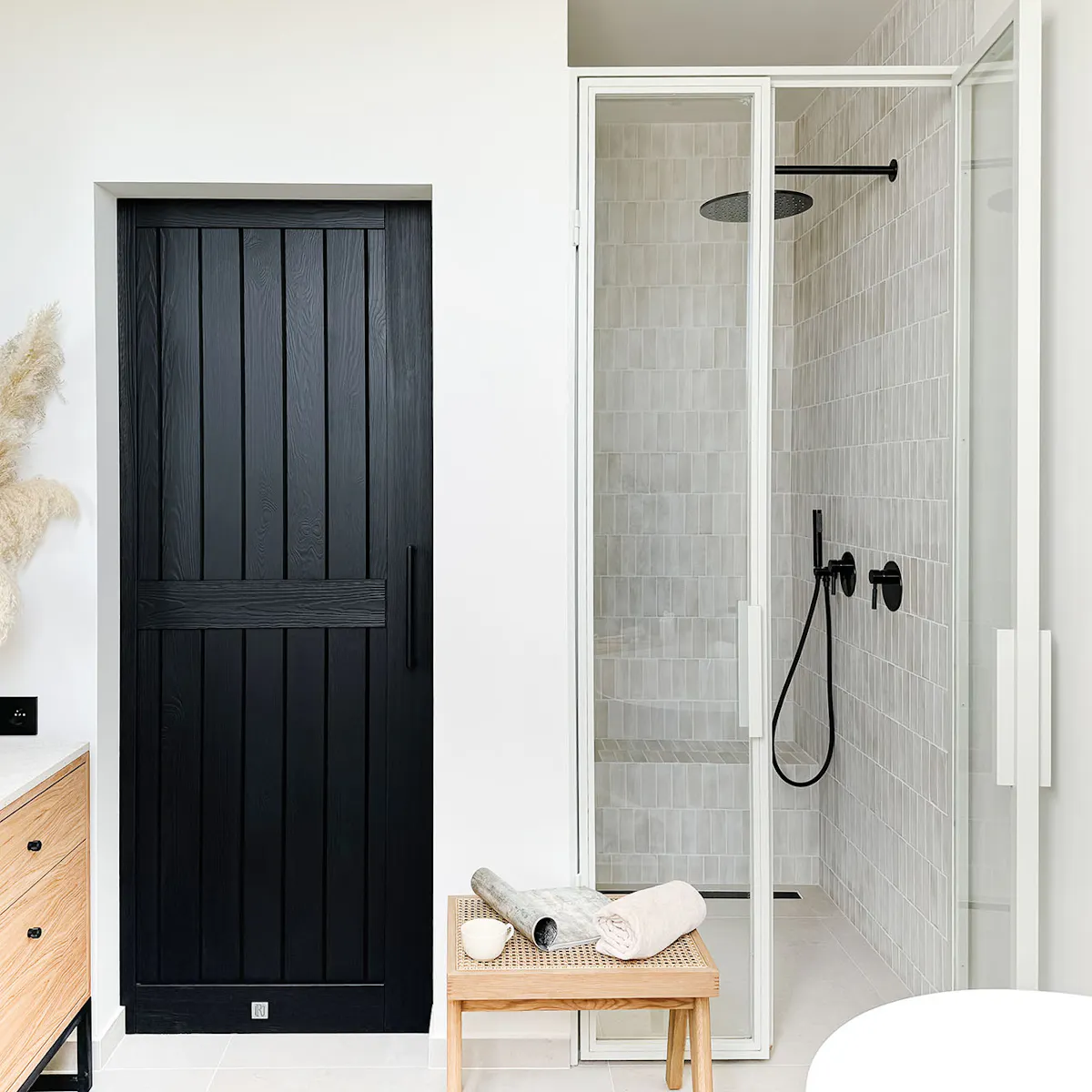 porte en bois noire à côté de la niche avec une cabine de douche blanche