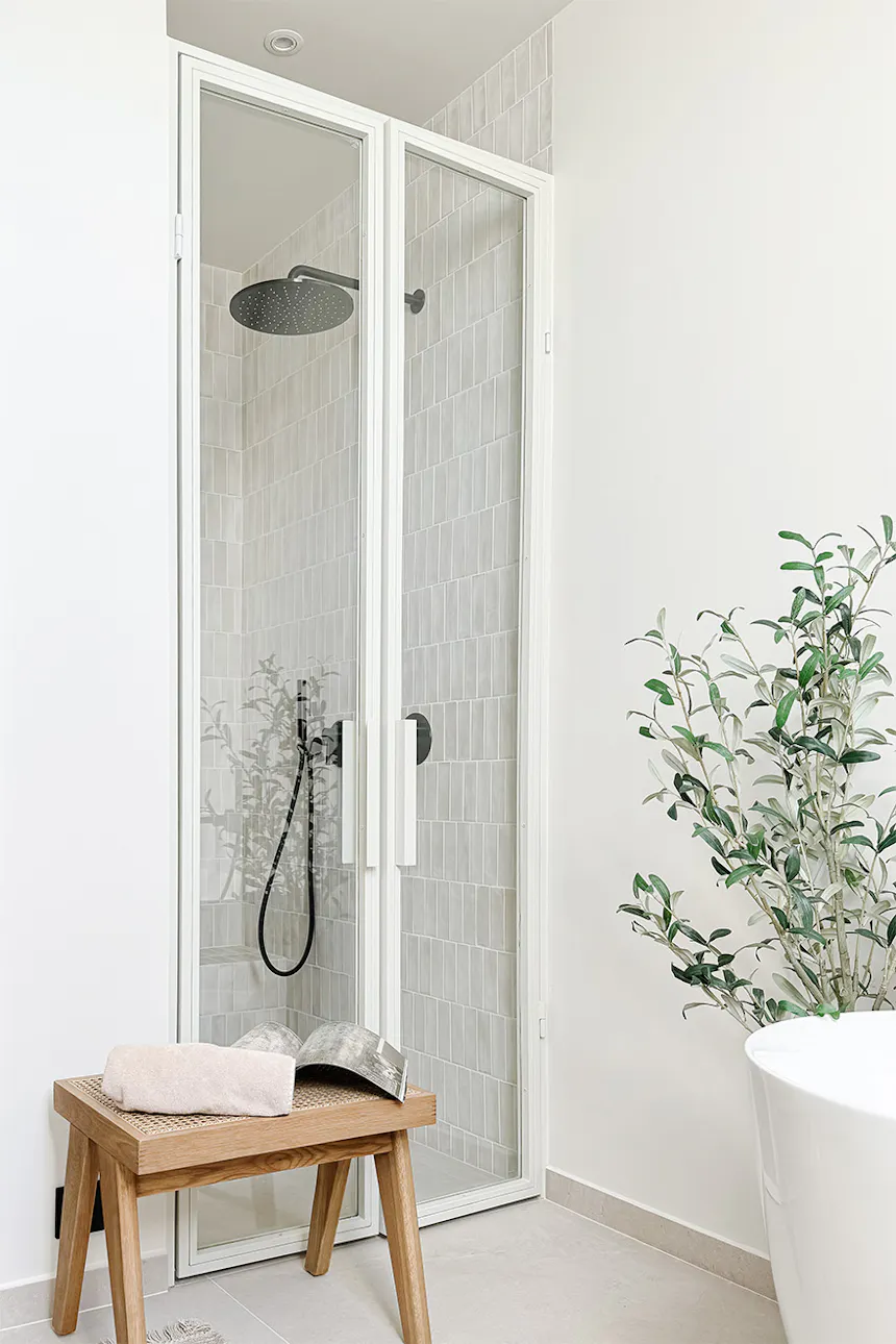 porte vitrée blanche donnant sur la cabine de douche située dans l'alcôve
