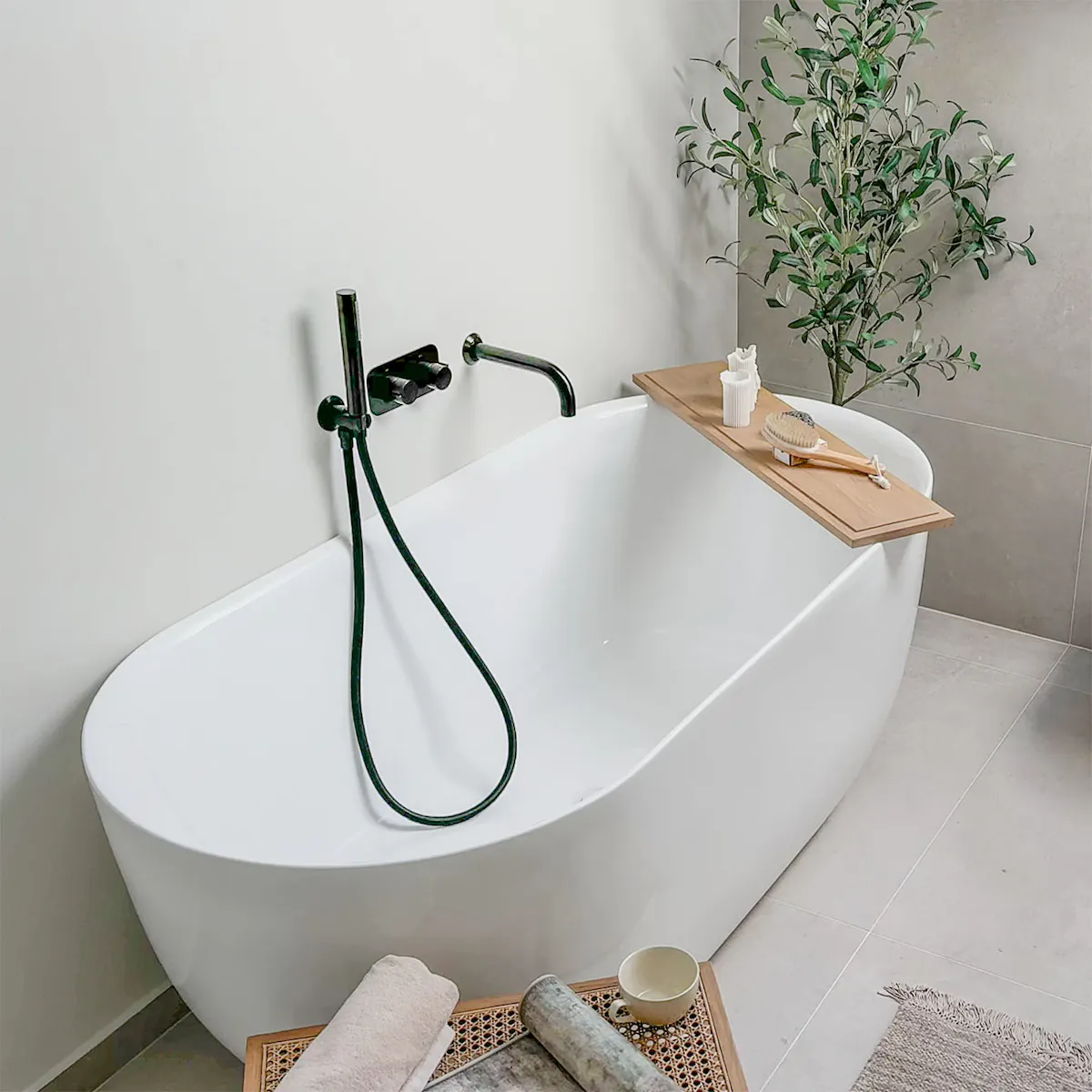 baignoire ovale blanche avec raccords noirs dans une salle de bain minimaliste